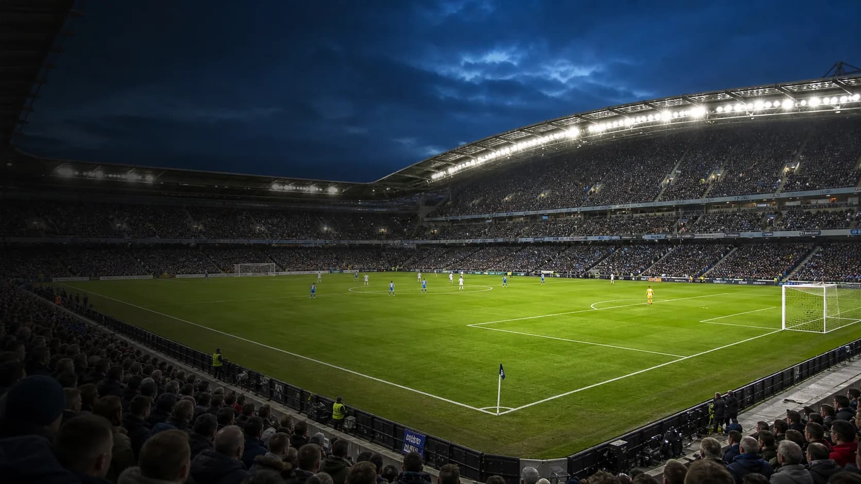 A floodlit modern football stadium before a Premier League match